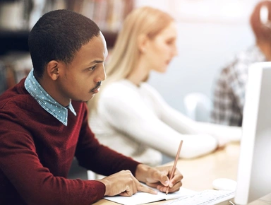 Etudiant écrivant sur un carnet