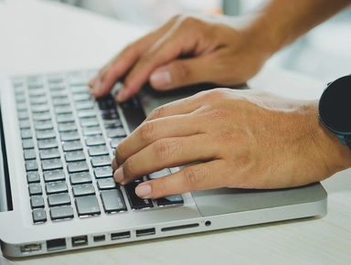 Deux mains tapant sur un clavie d'ordinateur portable