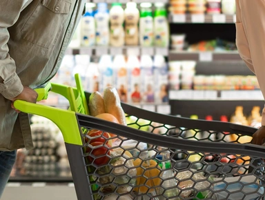 Deux personnes autour d'un caddie de courses dans un supermarché
