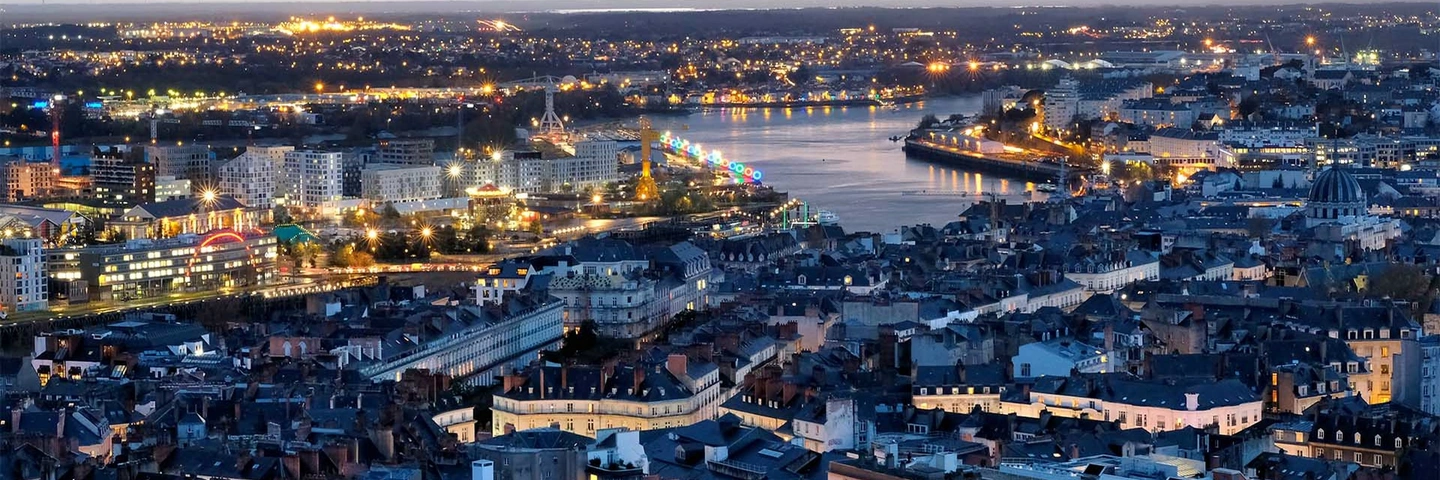 Ville moyenne française située sur un fleuve, de nuit 