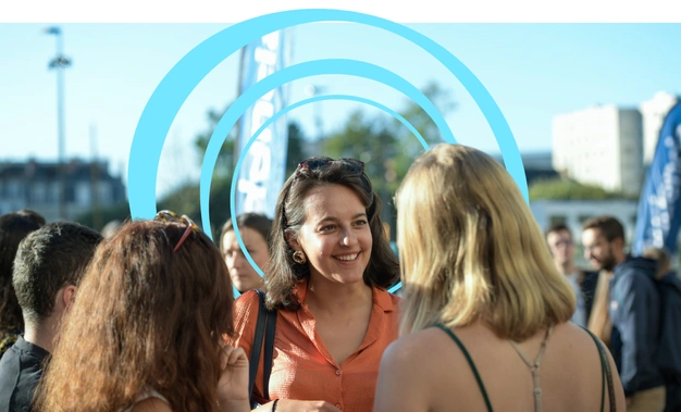 Une étudiante d'Audencia souriante discute avec deux autres étudiantes