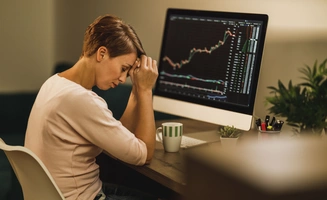 Femme stressée devant son ordinateur, ordinateur avec un graphique de croissance