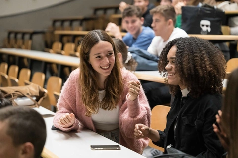 Etudiantes riant dans un amphithéâtre